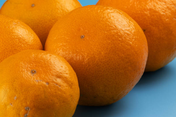 istock Yellow and ripe tangerines on a blue background. 1190973815
