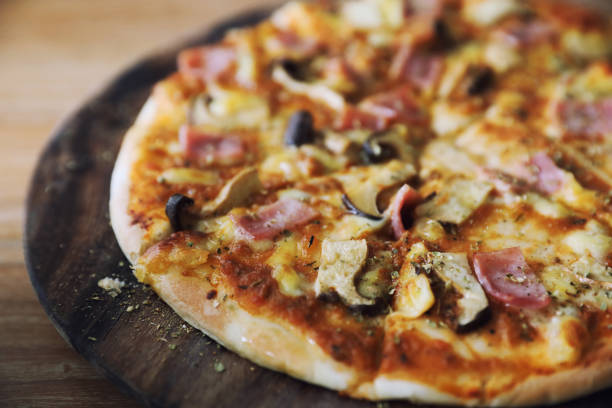 istock pizza ham and mushroom on wood background 1190978761