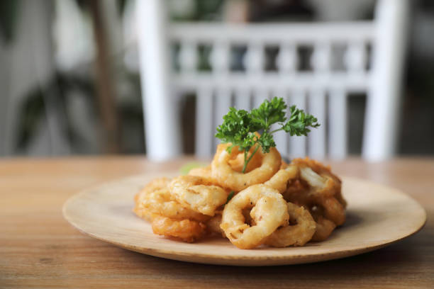 Caramari , Appetizer Crispy fried squid ring with tartar sauce on wood background traditional italian food