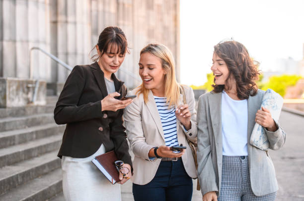 istock Three Smiling Female Students Pausing to Check Smart Phone 1190982072
