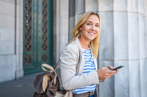 relaxed blonde law student standing at entrance to building - 5600 imagens e fotografias de stock