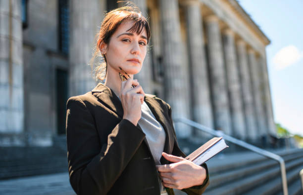 istock Serious Brunette Law Student Holding Glasses and Book 1190982114