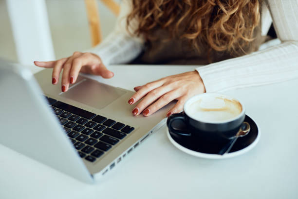 istock Attractive young curly brunette enjoying her coffee/tea and working on laptop 1190984350