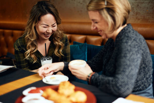 istock Two female friends in a cafe having coffee, smiling and chatting 1190985652
