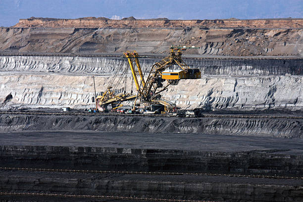 huge and deep  coal mine with excavator machine in europe stock photo