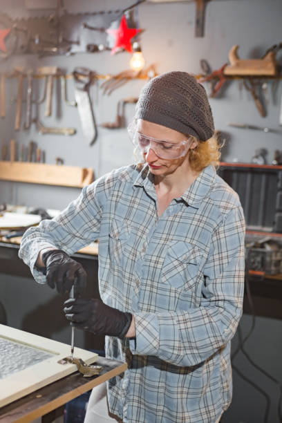 istock Carpenter working on the old wood in a retro vintage workshop. 1190992640