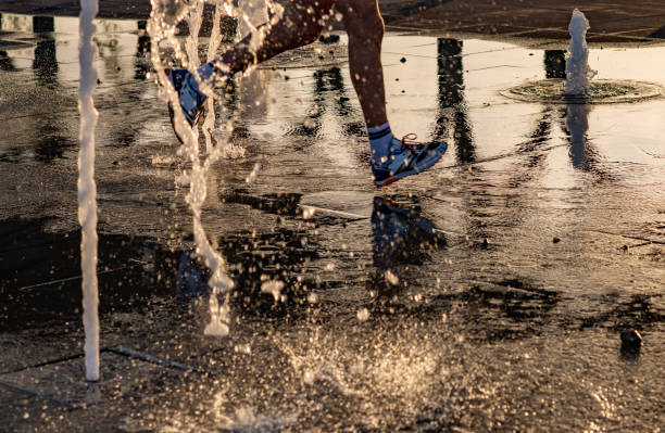 istock Feet running in water at sunset 1190993456