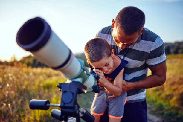 istock Father and son observing the sky with a telescope. 1190993623