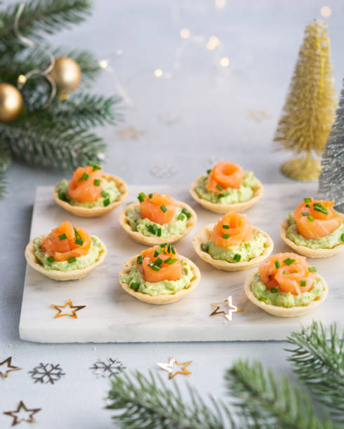 istock Canapes with smoked salmon, cream cheese and avocado on light background with space for text. Christmas and new year holidays background concept. Starters snacks recipe ideas. 1190995723