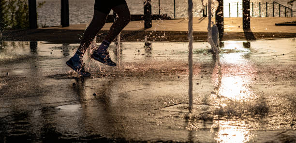 istock Feet running in water at sunset 1190999340
