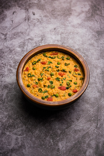 Vegetable masala oats khichadi served in a bowl. selective focus