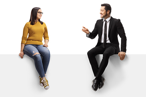 Businessman talking to a young female and sitting on a panel isolated on white background