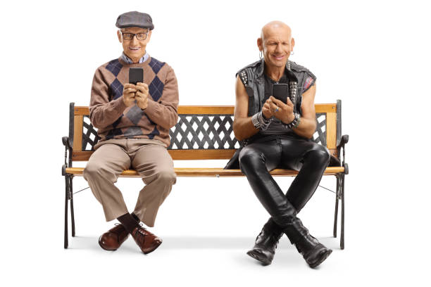 istock Elderly man and a punker using mobile phones and sitting on a bench 1191003041