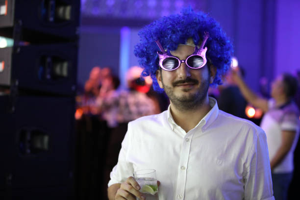 Young man wearing a blue toupee. Young man wearing a blue toupee during the eighties party. gay man men sunglasses party stock pictures, royalty-free photos & images