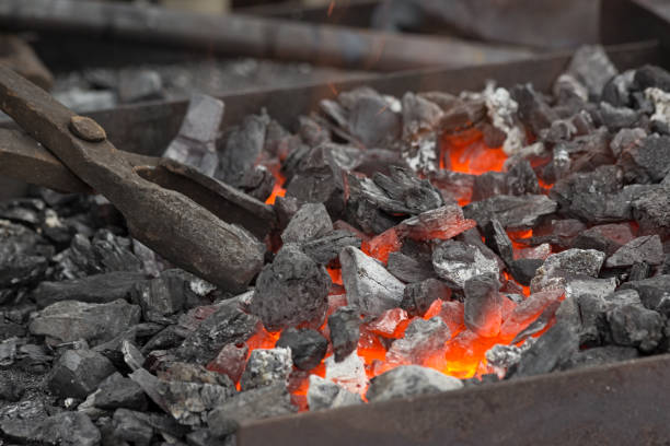istock A blacksmith sets up the brazier with embers with large coal tongs. 1191014204