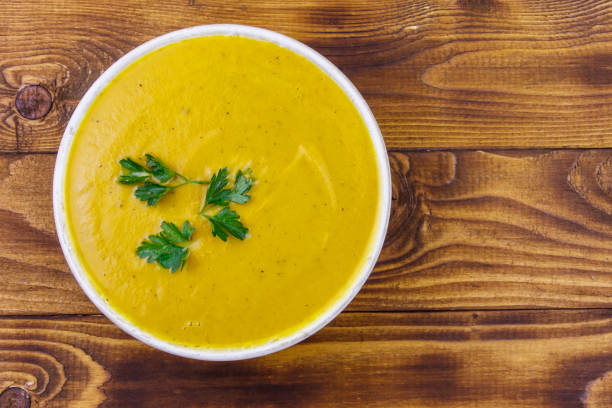 istock Pumpkin soup on a wooden table. Top view 1191015427