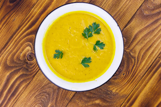 istock Pumpkin soup on a wooden table. Top view 1191015428