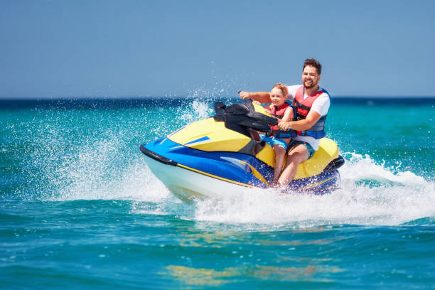 família, pai e filho felizes, excitados que têm o divertimento no esqui de jato em férias de verão - tropical climate family relaxation men - fotografias e filmes do acervo