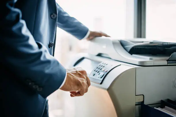 Midsection of businessman using photocopy machine at office