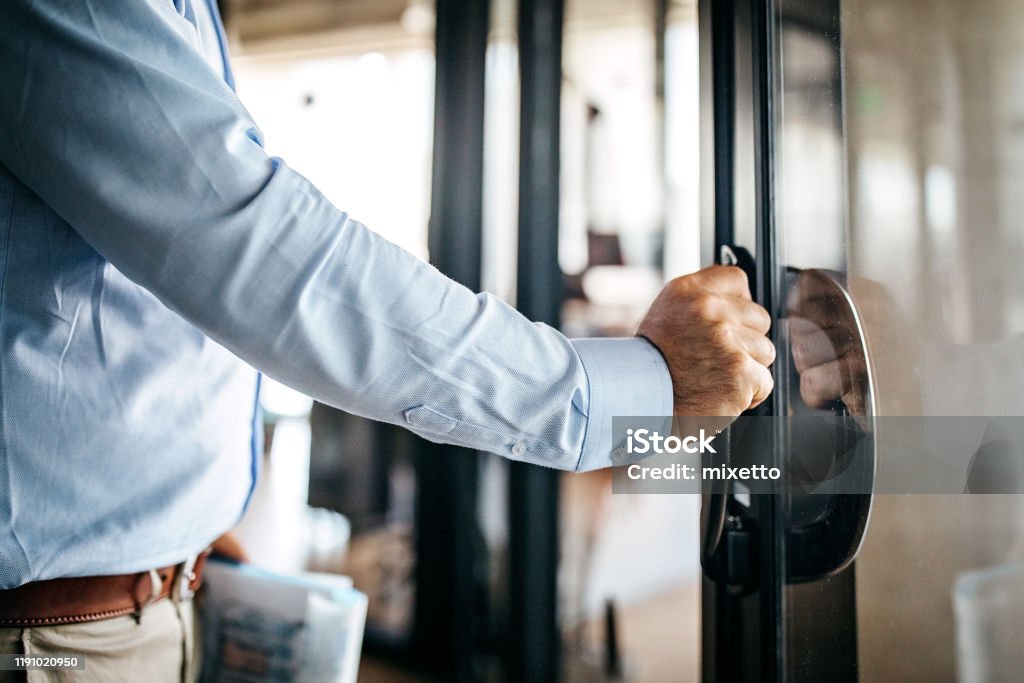 Businessman entering office cabin Businessman opening door entering office cabin Door Stock Photo