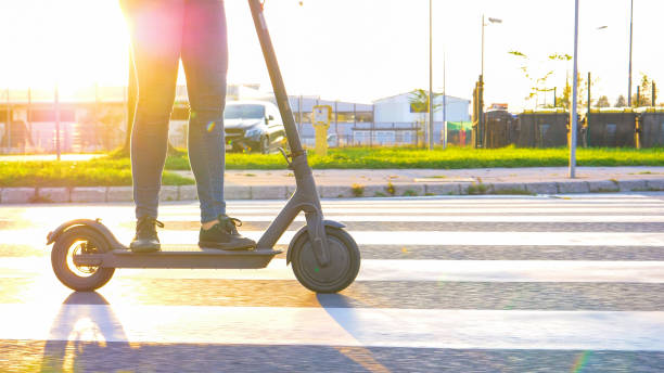 istock LENS FLARE: Modern girl rides through the suburbs on a cool high tech e scooter. 1191023792