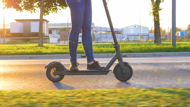 istock CLOSE UP Millennial in jeans speeds down the empty road on a high tech e-scooter 1191024367