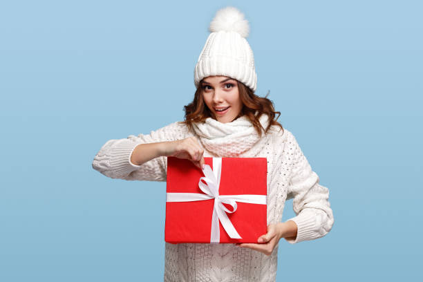 istock Young woman opening Christmas gift 1191024661
