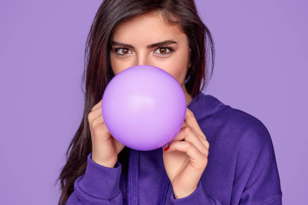 Young female inflating balloon