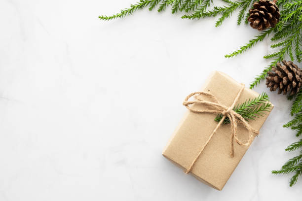 istock White marble table with Christmas decoration including gift box, pine branches and pine cones. Merry Christmas and happy new year concept. Top view with copy space, flat lay. 1191025475