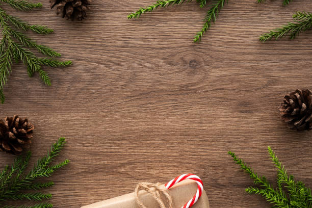 istock Wood table with Christmas decoration including gift box, candy cane, pine branches and pine cones. Merry Christmas and happy new year concept. Top view with copy space, flat lay. 1191025488