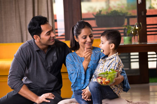 istock Happy woman feeding fruit salad to son 1191026882