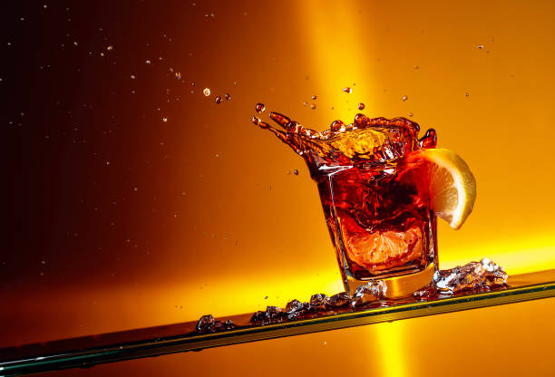 Slice of lemon falling into a glass of Cola.