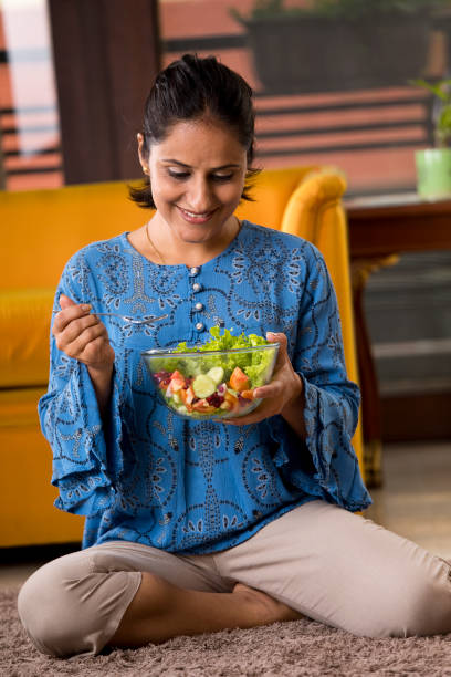 Woman eating fruit salad stock photo
