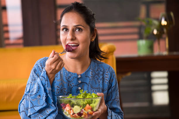 istock Woman eating fruit salad 1191031307