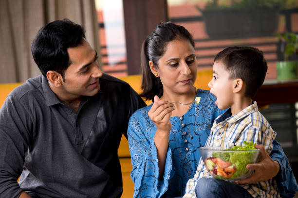 istock Happy woman feeding fruit salad to son 1191032013