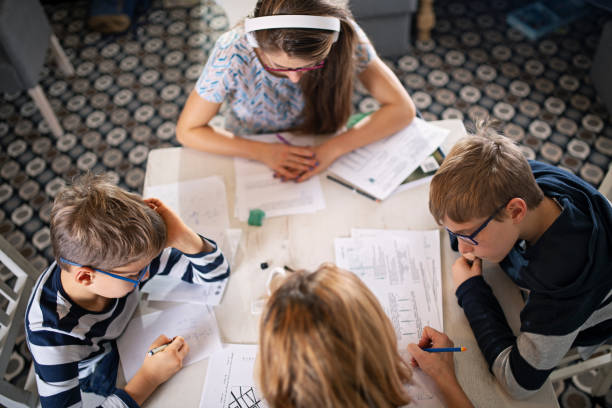 istock Mother and kids doing homework at home 1191035268