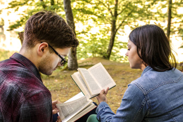 istock Couple Reading a Book On a Picnic 1191036426