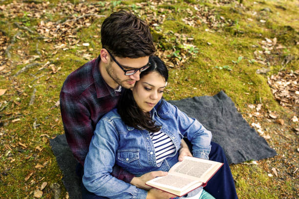 istock Couple Reading a Book On a Picnic 1191037036