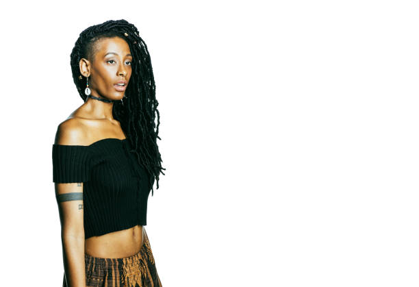 Side view of confident young woman on black background. African female model with hand on chin in studio.