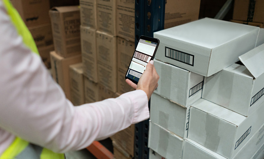 Close-up on a worker scanning products at a distribution warehouse