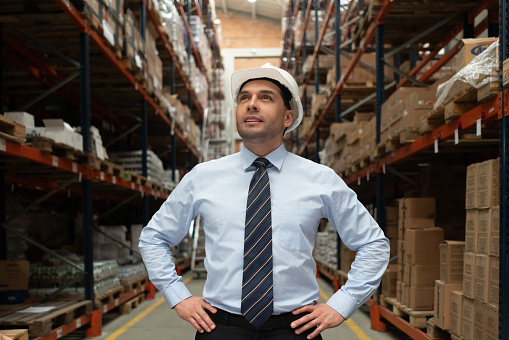 Portrait of an inspired business man working at a warehouse and looking thoughtful