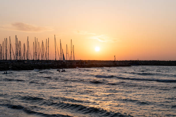 orange mediterranean sunset over yacht harbor in tel aviv, israel - sailboat sunset tel aviv sea imagens e fotografias de stock
