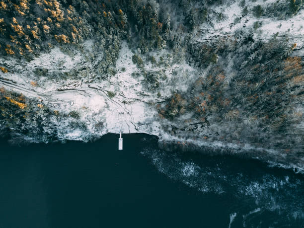 vue aérienne de la jetée en bois dans la forêt par le lac bleu dans le paysage rural d'hiver de finlande - finland sauna lake house photos et images de collection