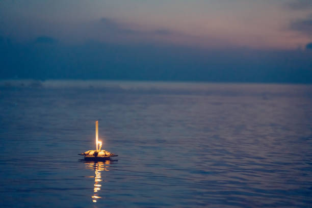 Loy Krathong, view evening of Krathong made from banana leaves floating in the river with colorful of sunset background Loy Krathong, view evening of Krathong made from banana leaves floating in the river with colorful of sunset background. krathong stock pictures, royalty-free photos & images