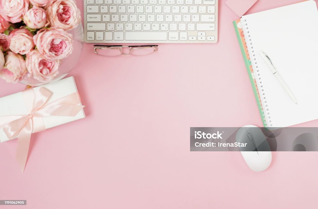 Flat Lay Top View Womens Office Desk On Pink Background Selective Focus  Female Workspace With Laptop Beautiful Pink Roses Flowers In A Vase Gift  Box Accessories Notebooks Glasses Copy Space Stock Photo -