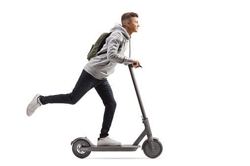 Estudiante masculino con una mochila montando un scooter eléctrico photo