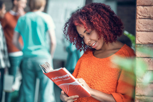 istock Curly red-haired student feeling involved in reading Chinse book 1191064289