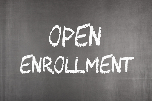 Open enrollment written on blackboard. Health concept