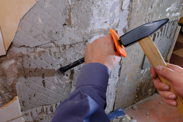 istock Removing old tiles from the wall in the kitchen using a chisel with a special plastic nozzle for safety when hammering 1191066249