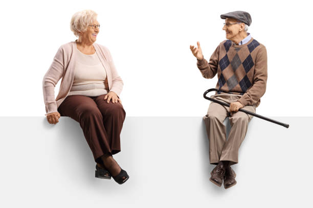 istock Senior man talking to a senior woman while sitting on a blank panel 1191070006